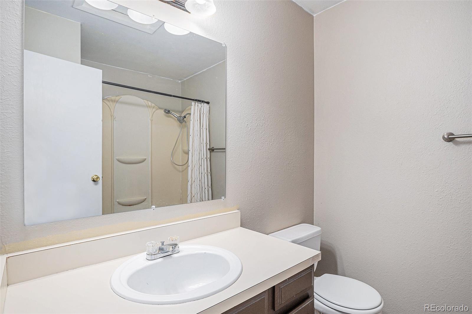 8915 Field Street, Unit 113 Westminster, CO 80021 - Photo 17 of 38 a bathroom with a sink a toilet and mirror