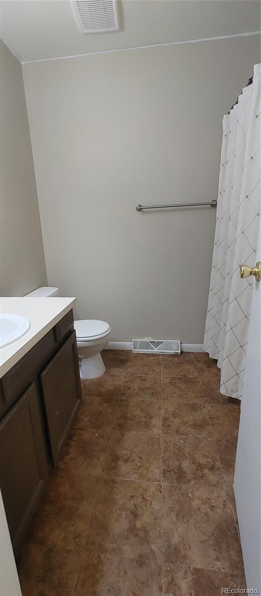 8915 Field Street, Unit 113 Westminster, CO 80021 - Photo 19 of 38 a bathroom with a granite countertop toilet and a sink