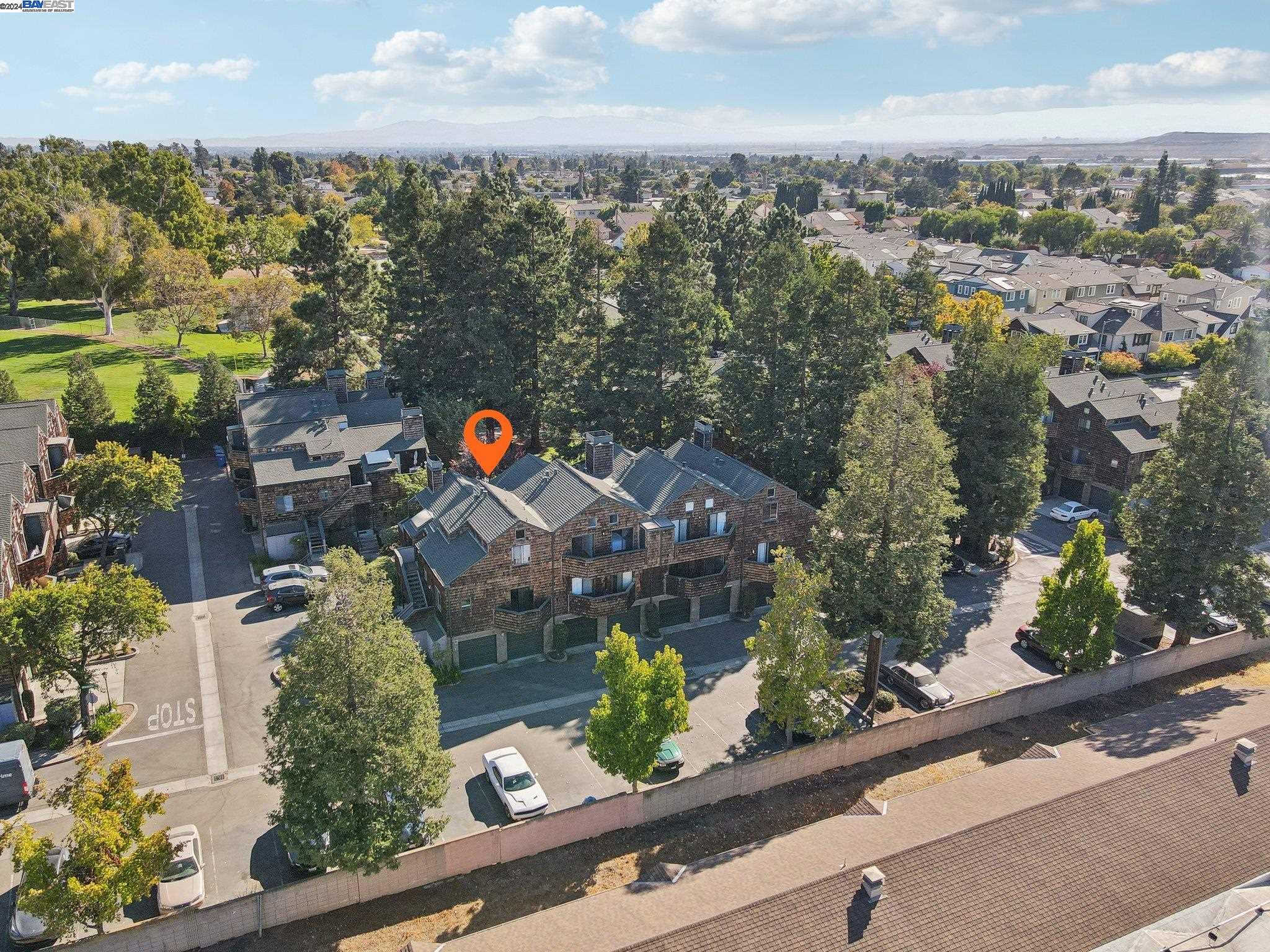 an aerial view of a house with a garden and mountain view in back
