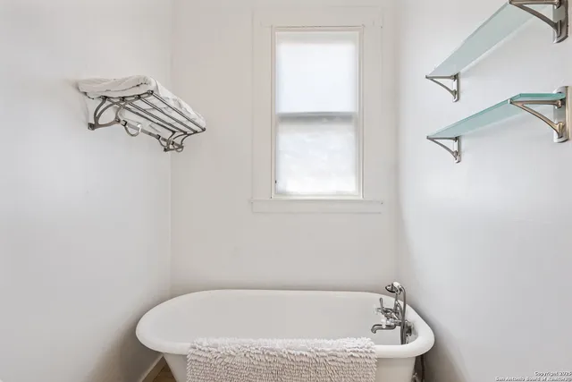 a white bath tub sitting next to a white cabinet