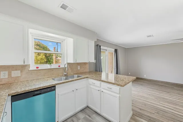 a kitchen with a sink cabinets and window