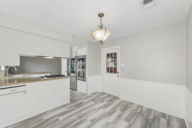 a kitchen with stainless steel appliances granite countertop a sink and a refrigerator
