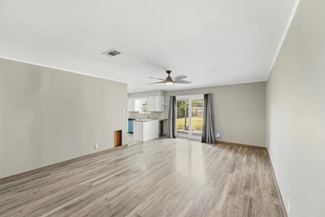 a view of a room with wooden floor and a window