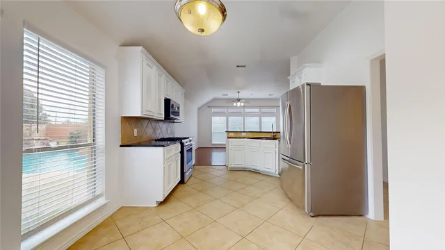 a kitchen with stainless steel appliances a refrigerator and a stove top oven