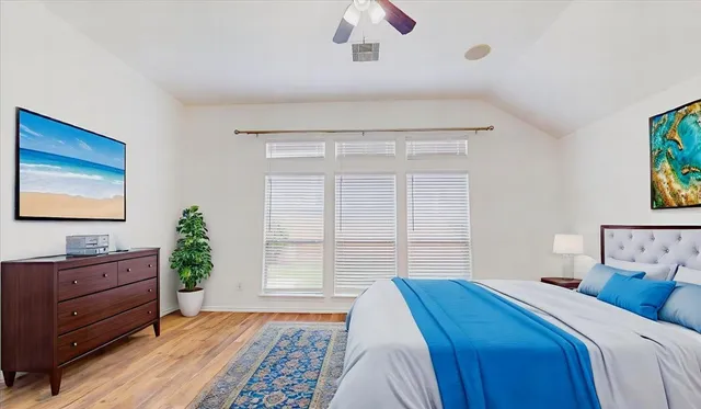 a bedroom with a bed and a dresser next to a window