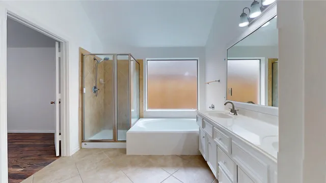 a spacious bathroom with a tub sink and mirror