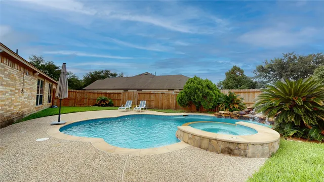 a view of a house with swimming pool and a yard