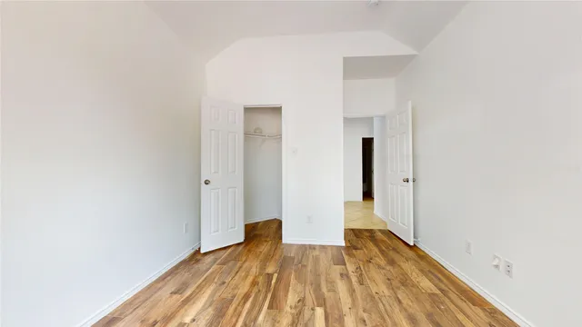 a view of a room with wooden floor and a ceiling fan