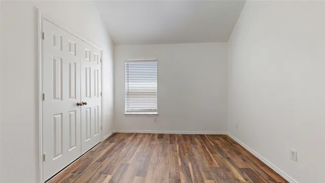 a view of a room with wooden floor and window