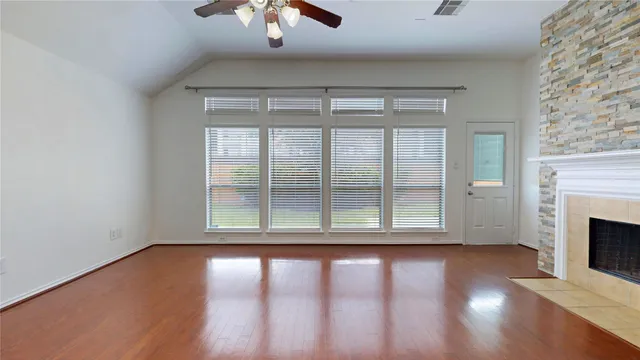 a view of empty room with wooden floor and fireplace