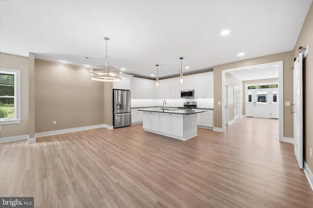 a view of kitchen with cabinets stainless steel appliances with wooden floor