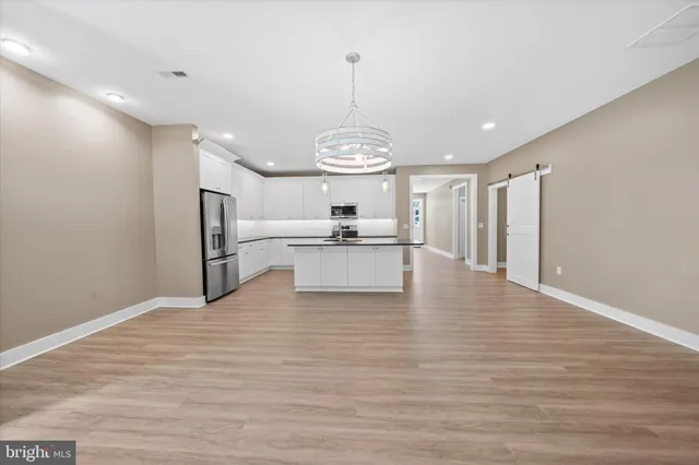 a view of a kitchen with a sink dishwasher a refrigerator and wooden floor