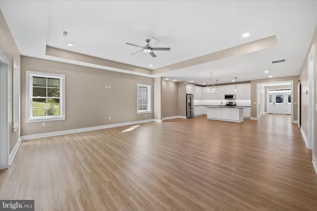 a view of empty room with kitchen and window