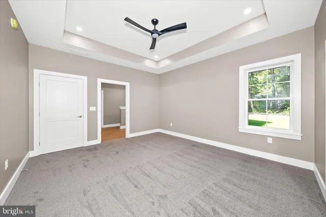 an empty room with windows and ceiling fan