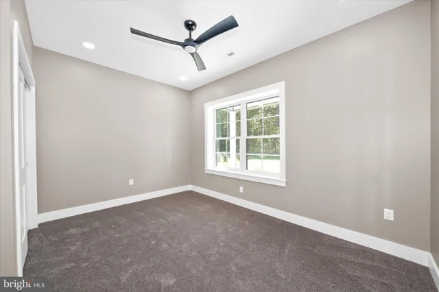 an empty room with a window and a fan