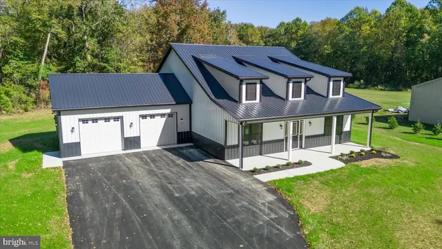 a view of a house with a yard and sitting area