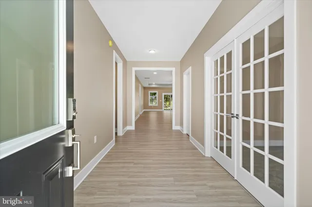 a view of a hallway with wooden floor and staircase