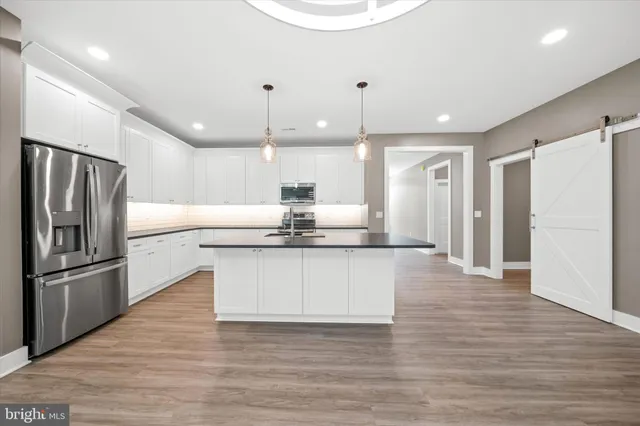 a kitchen with stainless steel appliances granite countertop a refrigerator a sink and a stove