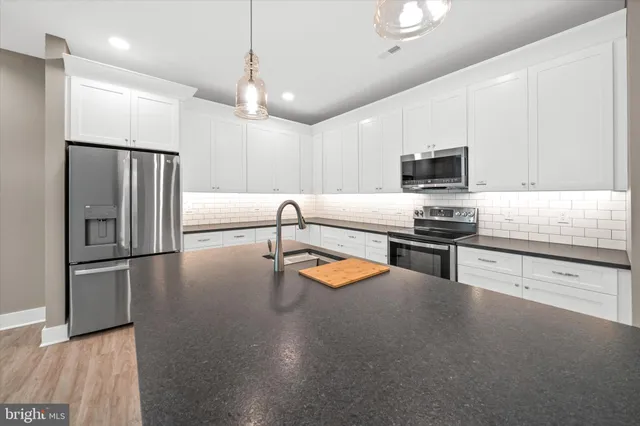 a kitchen with kitchen island a counter top space appliances and cabinets