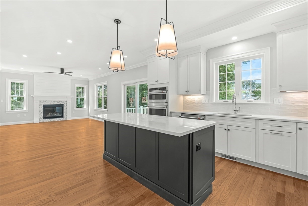 26 Flagg Street Woburn, MA 01801 - Photo 11 of 41 a kitchen with stainless steel appliances granite countertop a sink a stove and a wooden floor
