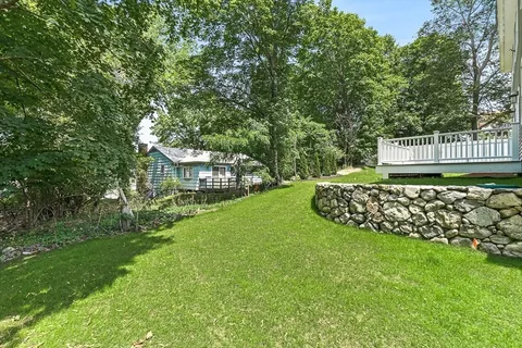 a view of a house with a yard and sitting area