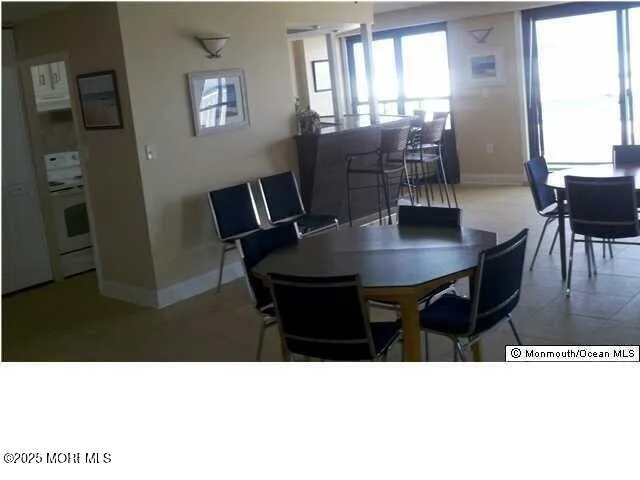 a black and white photo of a dining room with furniture and window