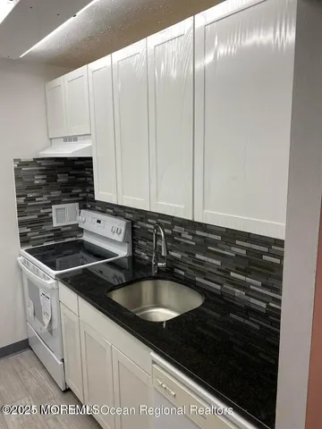 a kitchen with granite countertop a sink and a stove