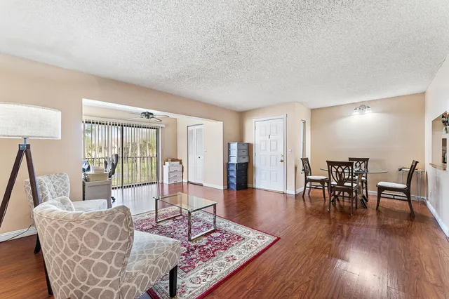 a living room with furniture a window and wooden floor