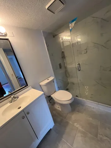 a bathroom with a toilet a sink and shower