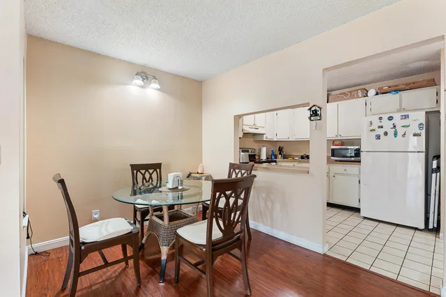 a kitchen with a dining table chairs and refrigerator