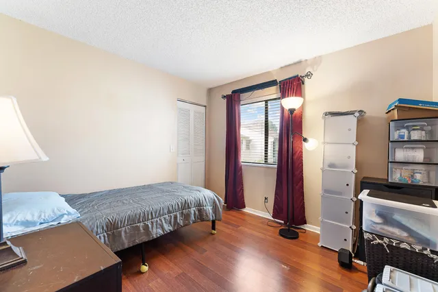 a bedroom with bed and wooden floor