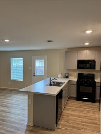 a kitchen with stainless steel appliances granite countertop a stove a sink and a microwave