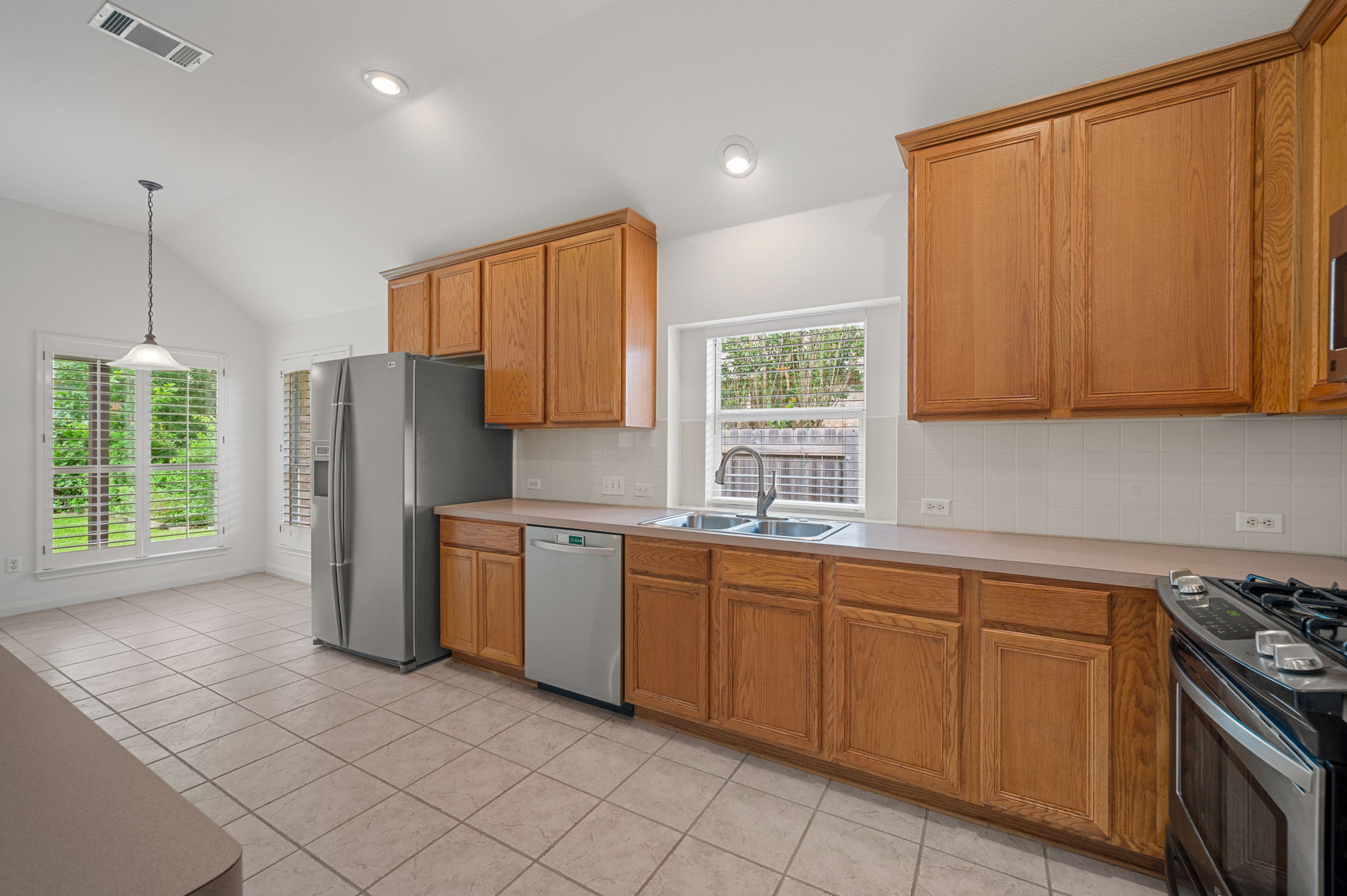 9201 La Siesta Bend Austin, TX 78749 - Photo 13 of 37 a kitchen with stainless steel appliances granite countertop a stove a sink dishwasher and a refrigerator