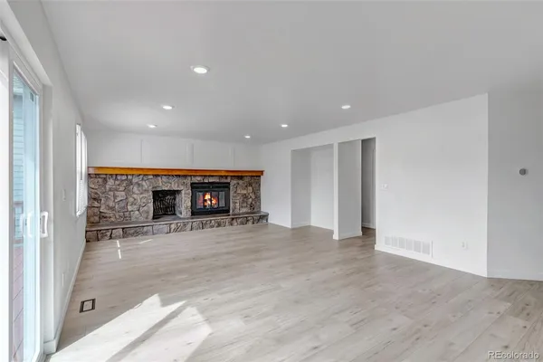 a view of empty room with kitchen and window