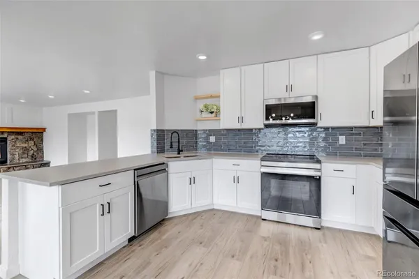 a kitchen with cabinets stainless steel appliances and a window