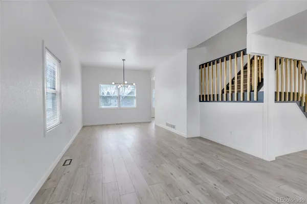a view of staircase with wooden floor and a chandelier