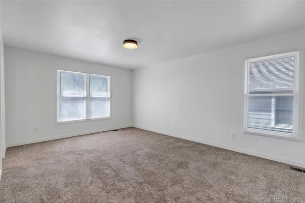 an empty room with windows and closet