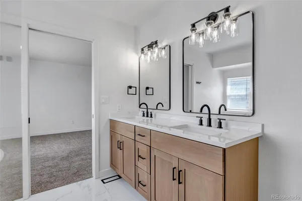 a bathroom with a double vanity sink toilet and mirror