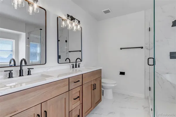 a bathroom with a sink a toilet and shower