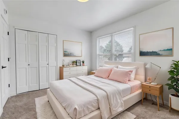 a bedroom with a bed and a painting on the wall