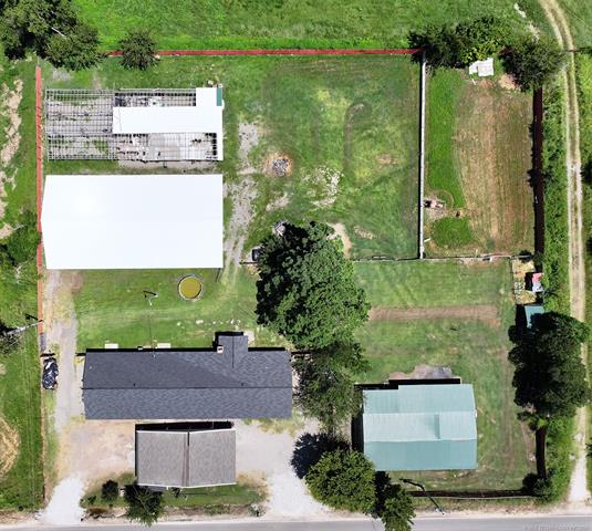 107903 South 4570 Road Sallisaw, OK 74955 - Photo 31 of 35 Expansive property featuring a main structure with a dark shingle roof, multiple outbuildings with varying roof colors, and a significant open field area