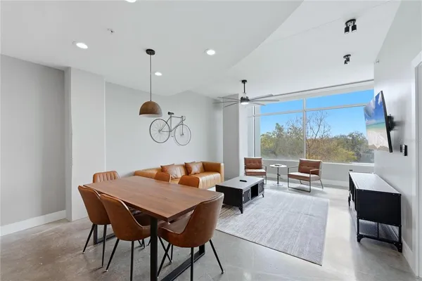 a dining room with wooden floor a glass table and chairs