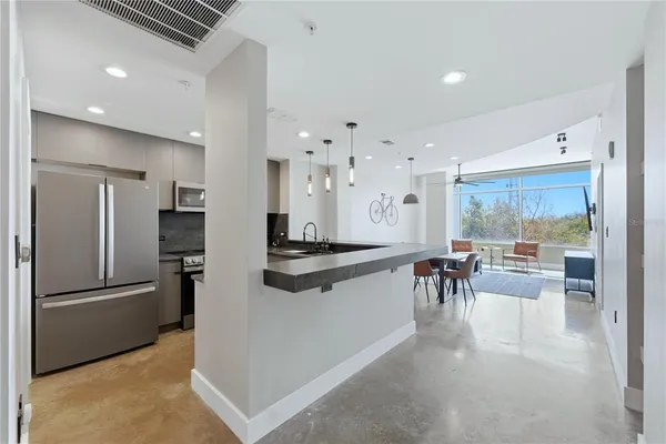 a kitchen with stainless steel appliances granite countertop a refrigerator and a stove top oven