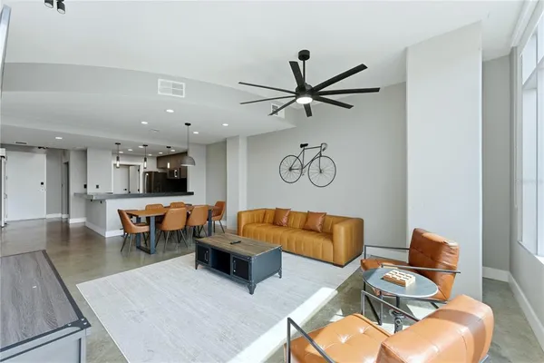 a living room with furniture kitchen view and a window