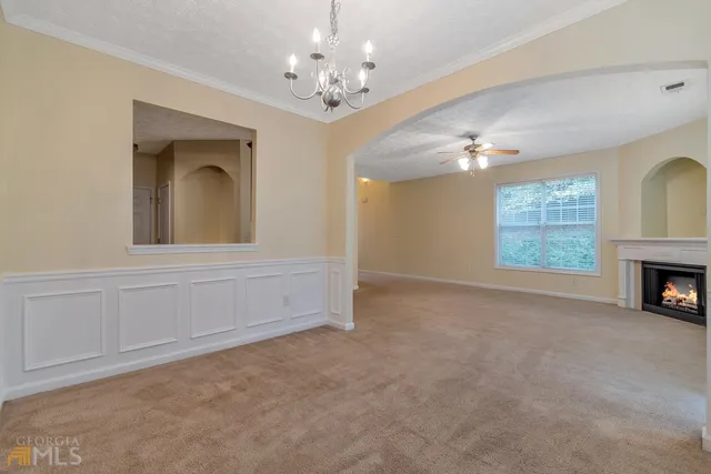 en empty room with windows and fireplace