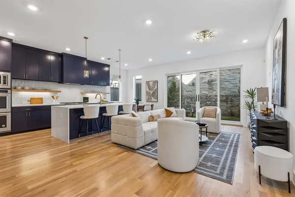 a living room with furniture kitchen and a wooden floor