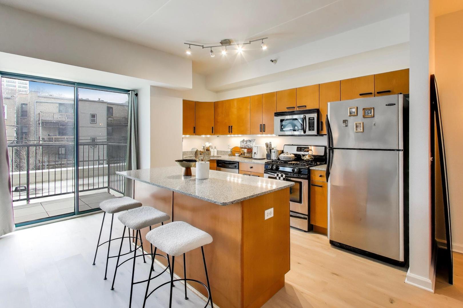 4848 North Sheridan Road, Unit 203 Chicago, IL 60640 - Photo 7 of 32 a kitchen with stainless steel appliances granite countertop a refrigerator a sink and a stove