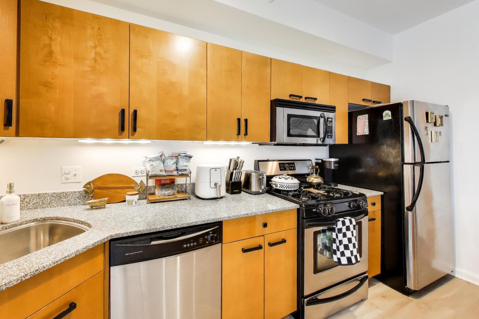 4848 North Sheridan Road, Unit 203 Chicago, IL 60640 - Photo 8 of 32 a kitchen with stainless steel appliances granite countertop a sink stove and refrigerator