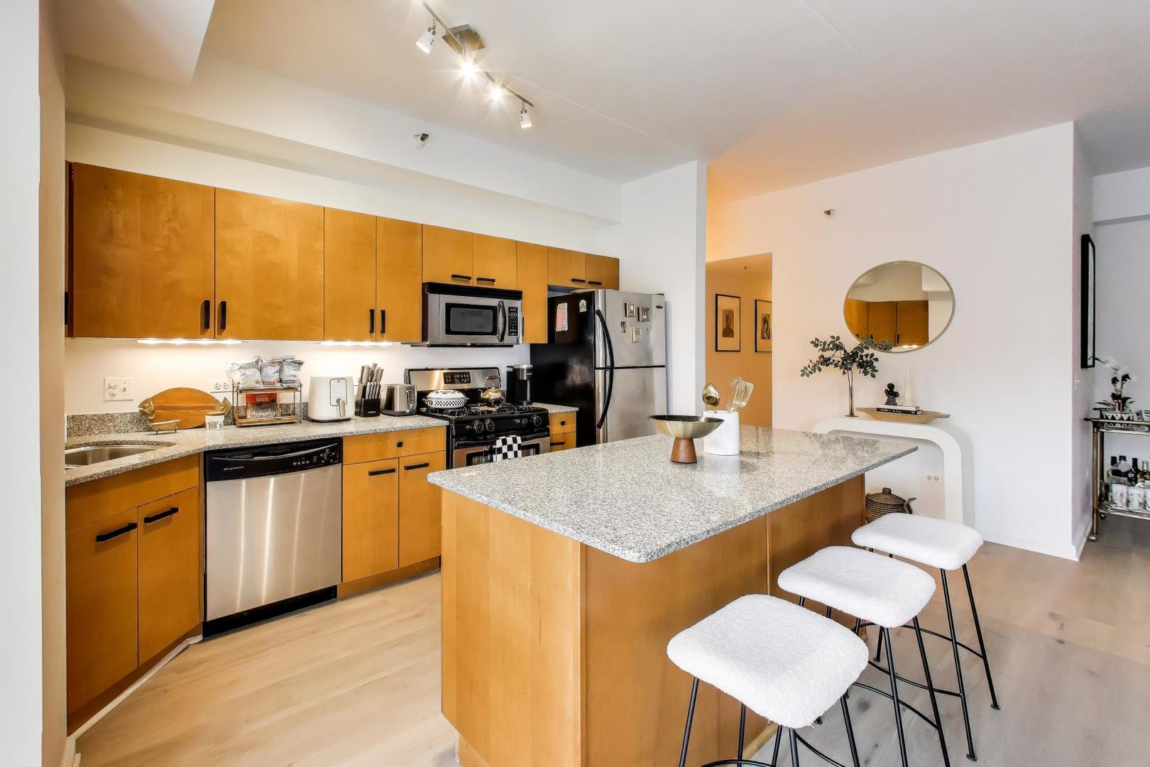 4848 North Sheridan Road, Unit 203 Chicago, IL 60640 - Photo 9 of 32 a kitchen with a table chairs sink and a stove