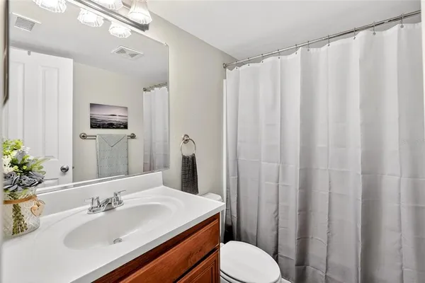 a bathroom with a sink a toilet and shower curtain